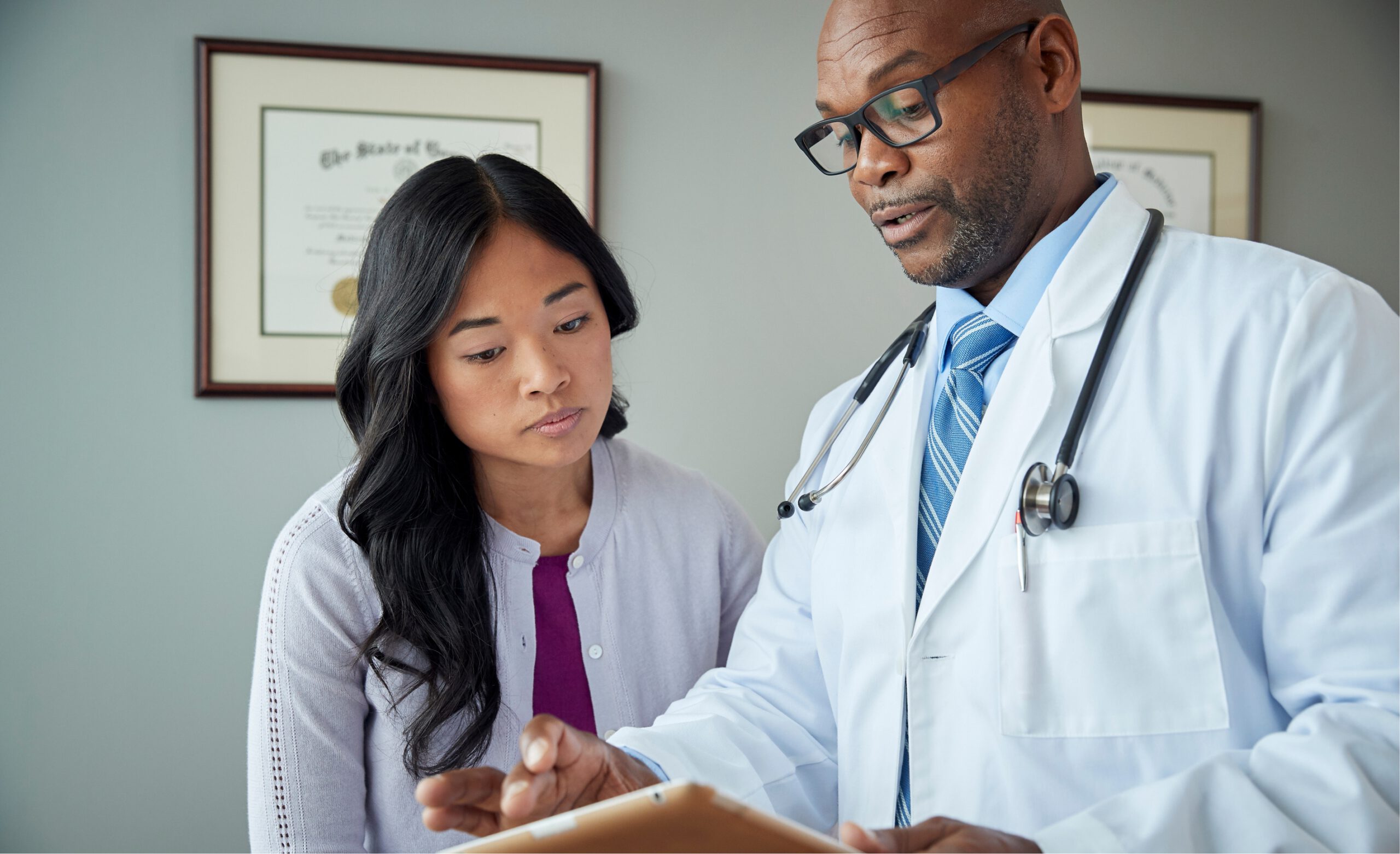 Medical specialist discussing with female patient in his clinic.